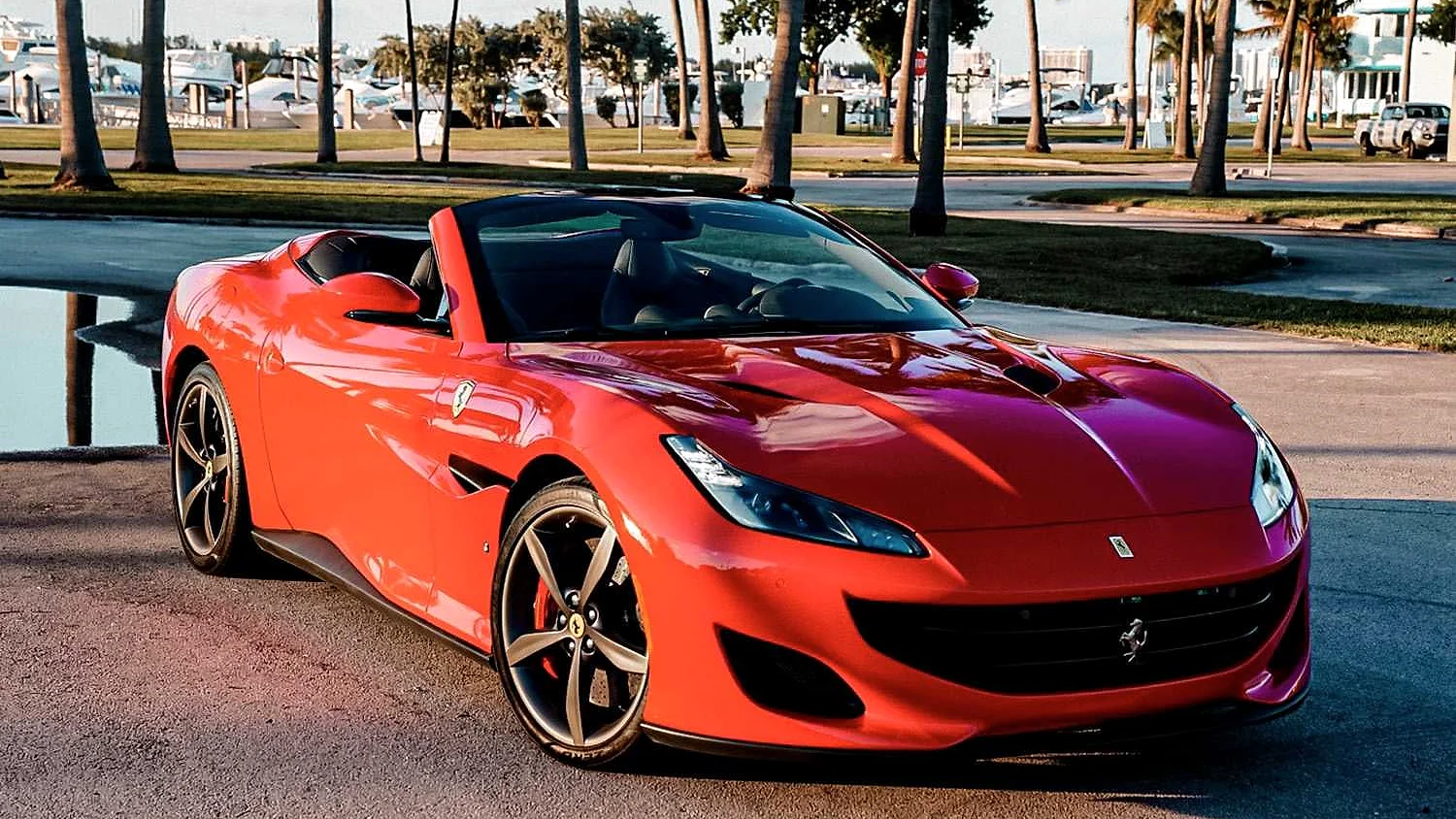 Red Ferrari Portofino Spyder beside a Miami marina