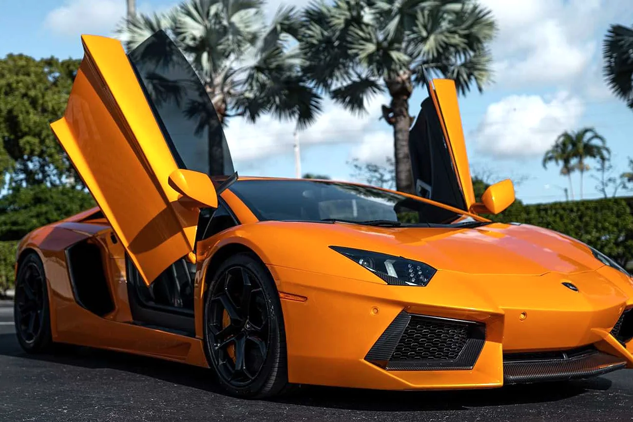 Orange Lamborghini Aventador beneath Miami palms
